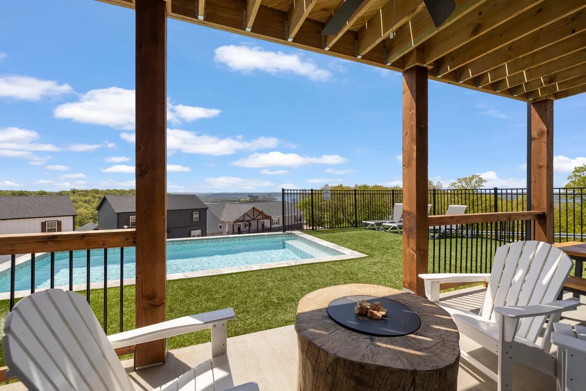 This exterior shot features a sparkling swimming pool surrounded by an inviting wooden deck, an outdoor seating area, and a lush green lawn. The scene is tranquil, with sunset hues in the background, showcasing the perfect spot for both recreation and relaxation.