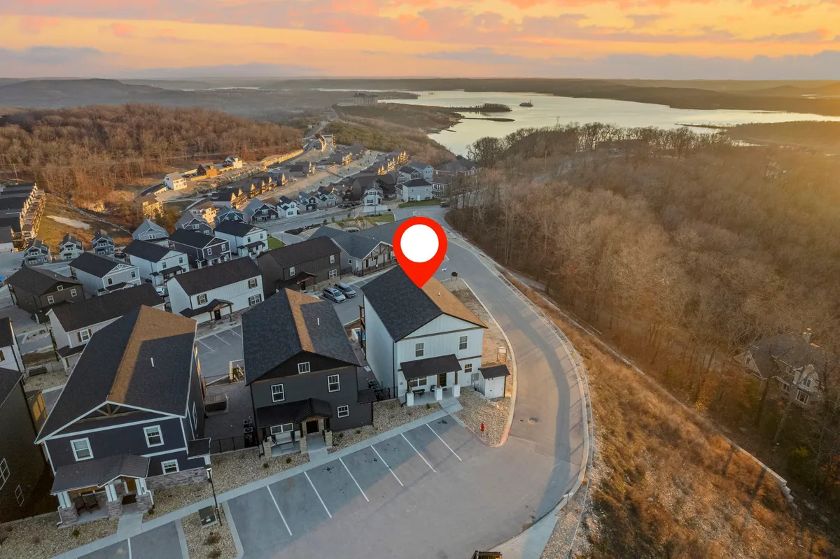 A serene scene showing newly constructed homes set along a winding road, with natural landscape and a glowing sunset sky in the background. The environment is inviting for walking, biking, and enjoying nature in a community setting.